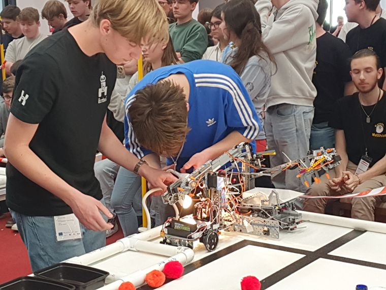 Students making a last-minute adjustment to a Botball robot