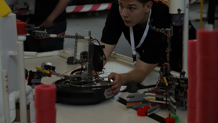 A student working on a custom-built competition robot