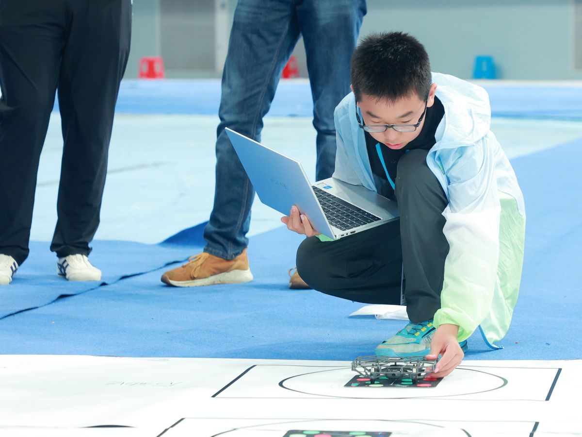 A student preparing a drone for the Aerial Junior challenge